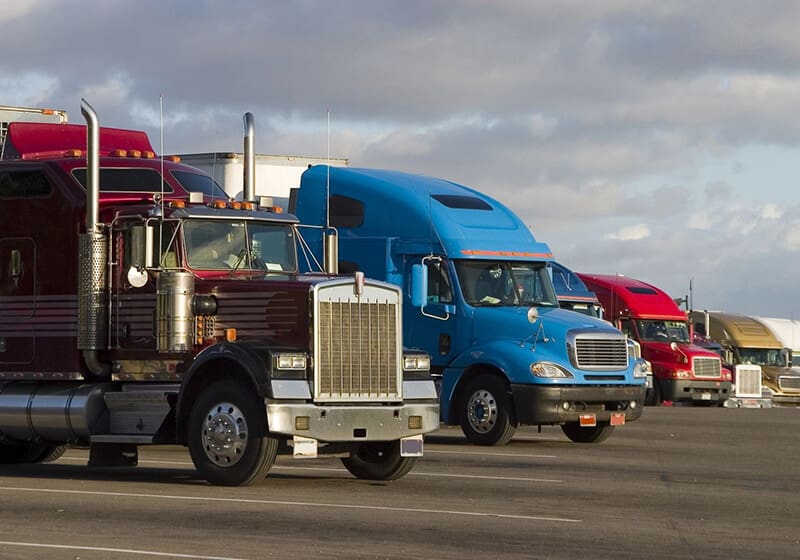 A group of trucks driving down the road.