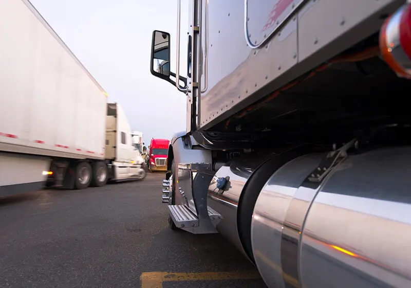 A close up of the side of a truck on a highway.