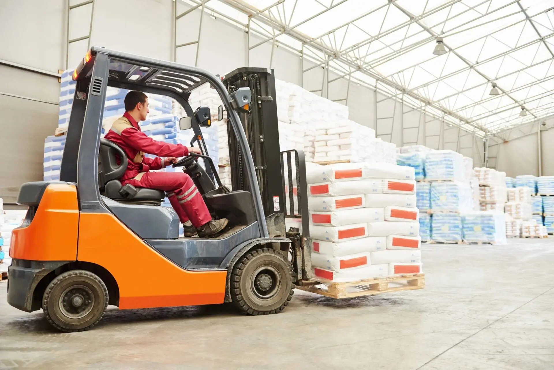 A man driving a forklift in an industrial setting.